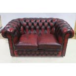 A HIDE UPHOLSTERED TWO SEATER LIBRARY SETTEE with deep buttoned upholstered scroll over back and