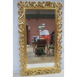 A CONTINENTAL GILT FRAMED MIRROR the rectangular bevelled glass plate with a pierce intertwined