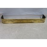 A 19TH CENTURY BRASS FENDER embossed with ribbon tied swags on moulded base 153cm x 28cm