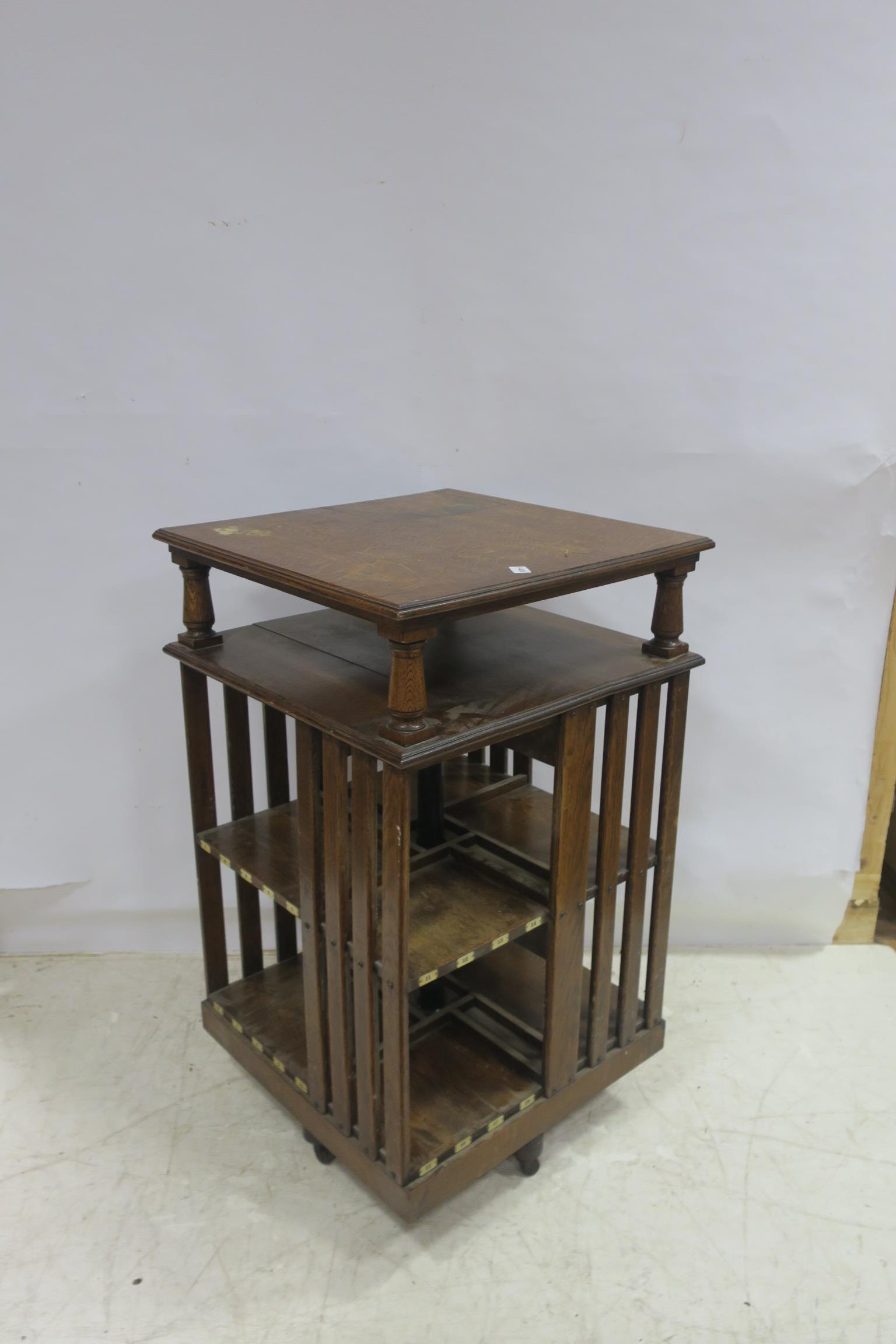 A 19TH CENTURY OAK REVOLVING BOOK STAND the square moulded top above an open shelf the base