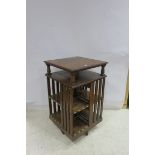 A 19TH CENTURY OAK REVOLVING BOOK STAND the square moulded top above an open shelf the base