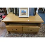 A TEAK TV STAND of rectangular form with open shelf and two frieze drawers on standard end supports