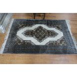 A PERSIAN WOOL RUG the grey and beige ground with central diamond panel with stylized flower heads