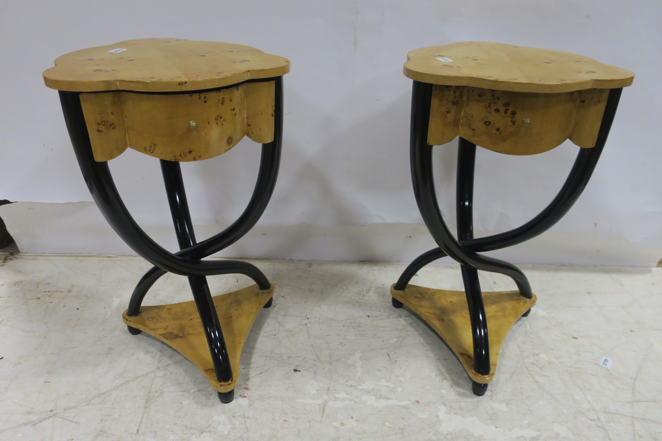 A PAIR OF ART DECO DESIGN WALNUT AND EBONISED OCCASIONAL TABLES each with a shaped top and frieze