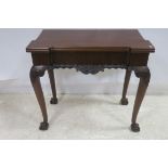 A GEORGIAN DESIGN MAHOGANY FOLD OVER CARD TABLE of inverted breakfront outline the hinged lid above