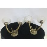 A PAIR OF BRASS TWO BRANCH WALL LIGHTS with scroll arms and circular back plate with moulded shades