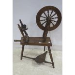 AN OAK SPINNING WHEEL of typical form 99cm (h) x 64cm (w) x 48cm (d)