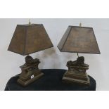 A PAIR OF COMPOSITION BRONZED TABLE LAMPS each of pillar form surmounted with a lion shown seated