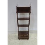 A MAHOGANY FOUR TIER OPEN FRONT BOOKCASE with pierced gables the base containing two long drawers