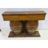 A HARDWOOD BAR UNIT the rectangular top above an open shelf raised on twin oak and brass bound half