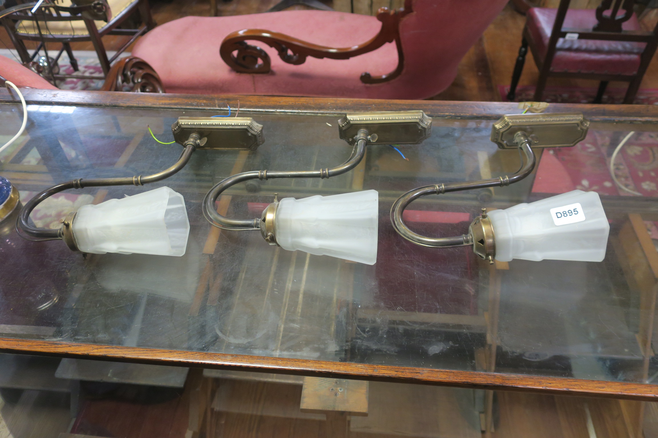 A SET OF THREE OXIDISED WALL LIGHTS with frosted glass shades