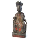 A carved and painted figure of a Chinese nobleman seated in an arm chair,