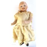 1920 A German bisque-headed baby doll, with moulded and painted hair, blue-grey glass eyes,