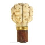 Japanese ivory, a carved ivory "many heads" cane handle,