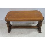 A GOTHIC DESIGN OAK COFFEE TABLE the rectangular top with canted angles raised on pierce standard
