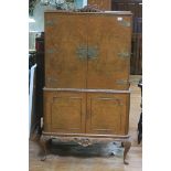 A GOOD VINTAGE WALNUT COCKTAIL CABINET the rectangular top with carved decoration above a pair of