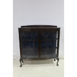 A CHIPPENDALE DESIGN MAHOGANY CHINA DISPLAY CABINET of bowed outline with gadrooned rim and