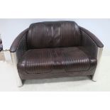 AN AVIATION WHITE METAL FRAME AND HIDE UPHOLSTERED TWO SEATER SETTEE with upholstered back seat and