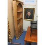 A PINE CORNER CABINET with open shelves and cupboard on bracket feet together with a cherrywood