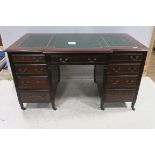 A 19TH CENTURY MAHOGANY DESK of rectangular breakfront outline the shaped top with tooled leather