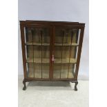 A MAHOGANY CHINA DISPLAY CABINET of slightly bowed outline shaped top with glazed doors on cabriole