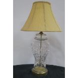A CUT GLASS TABLE LAMP of baluster form raised on a pierced brass base with pleated shade 73cm (h)