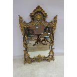 A CONTINENTAL GILT FRAME MIRROR the shaped plate within a pierced C scroll foliate of flower head