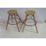 A SET OF FOUR HARDWOOD AND BRASS INDUSTRIAL STOOLS each with a circular dish seat on splayed legs