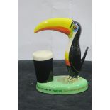 A CARLTON WARE GLAZED CHINA FIGURE modelled as a toucan inscribed Guinness is Good for You