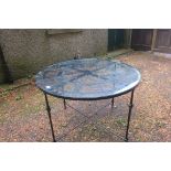 A WROUGHT IRON PATIO TABLE of circular form with glazed top depicting a clock face on square