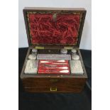 A 19TH CENTURY ROSEWOOD TRAVELLING CASE with fitted interior comprising lidded jars and bottles etc