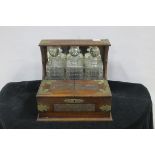A 19TH CENTURY CARVED OAK AND PLATED BOUND TANTALUS containing three decanters with stoppers 32cm