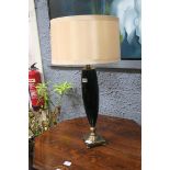 A BLACK PORCELAIN AND BRUSHED BRASS TABLE LAMP of ovoid tapering form on square base with shade
