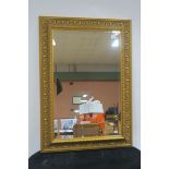 A CONTINENTAL GILT FRAMED MIRROR the rectangular bevelled glass plate within a foliate moulded