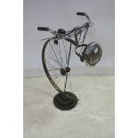 A VINTAGE TABLE LAMP in the form of a bicycle wheel with handlebars raised on a circular cog 89cm