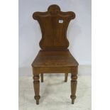 A 19TH CENTURY OAK HALL CHAIR with carved panel back and seat on baluster legs