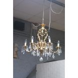 A GILT BRASS CUT GLASS SIX BRANCH CHANDELIER hung with pendent drops