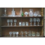 A COLLECTION OF GLASS ON THREE SHELVES to include decanters vases etc etc
