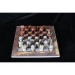 A MARBLE CHESS SET on board 25cm sq