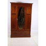 AN EDWARDIAN MAHOGANY AND SATINWOOD INLAID WARDROBE the outset moulded cornice above an oval