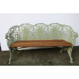 A CAST METAL LILY OF THE VALLEY PATTERN GARDEN BENCH with serpentine top rail with scroll arms with