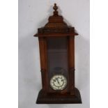 A CARVED CASED VIENNA WALL CLOCK the glazed door between reeded and foliate flower head carved