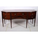 A GEORGIAN MAHOGANY CROSS BANDED SIDEBOARD of rectangular bowed outline the shaped top with frieze