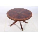 A MAHOGANY CROSS BANDED COFFEE TABLE the shaped top of circular outline above a turned column on