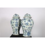 A PAIR OF ORIENTAL LIDDED GINGER JARS each of ovoid tapering form the white a blue ground decorated