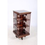 A 19TH CENTURY MAHOGANY REVOLVING BOOK STAND the square moulded top above open compartments and