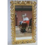 A CONTINENTAL GILT FRAMED MIRROR the rectangular bevelled glass plate within a pierced intertwined