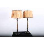 A PAIR OF BRONZED TABLE LAMPS each with a cylindrical spreading column above a circular dish foot