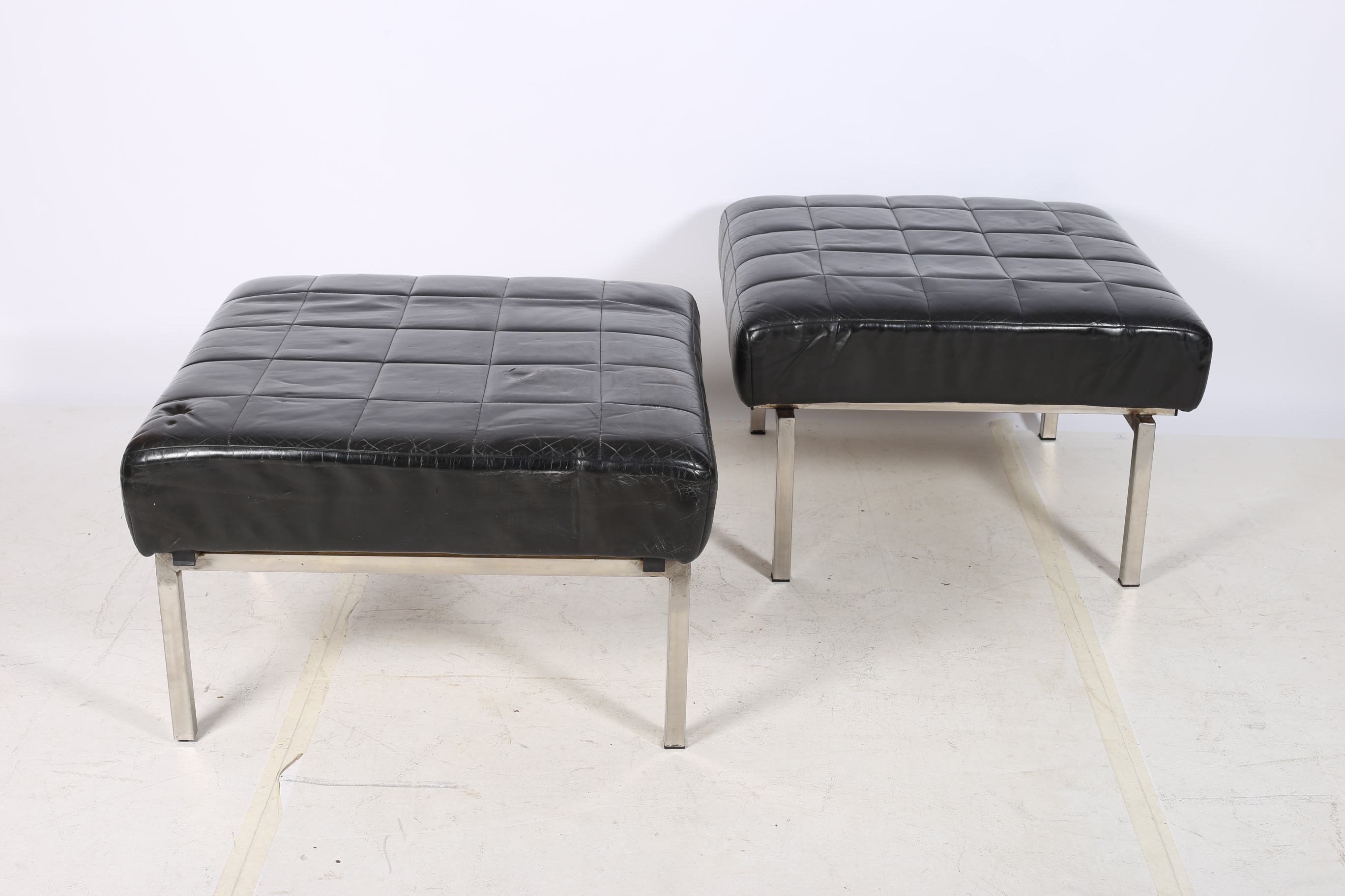 A PAIR OF RETRO HIDE UPHOLSTERED AND CHROME STOOLS each of a square outline with panelled seats on