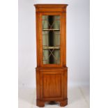 A SATINWOOD CORNER CABINET the moulded cornice above an astragal glazed door and cupboard between